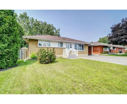 A house with a brown roof and a white fence.