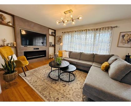 A living room with a grey couch, a coffee table, a television, and a fireplace.