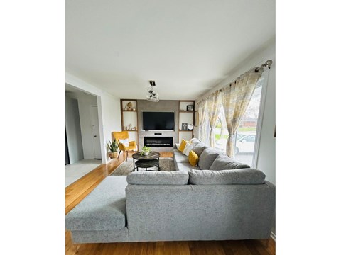 A living room with a grey couch and a television.