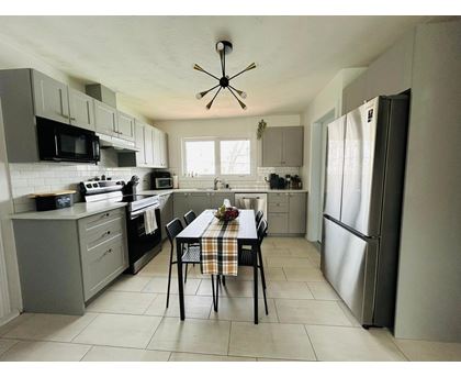 A kitchen with a table and chairs in the middle.