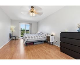 A bedroom with a bed, dresser, and window.