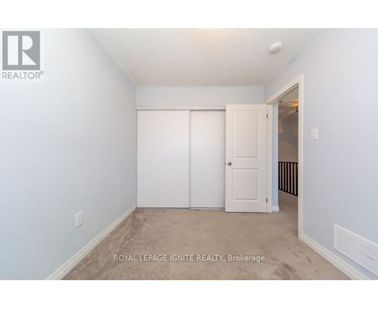 A white bedroom with a door and a window.