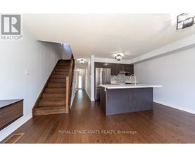 A spacious room with a staircase leading to the upper level.
