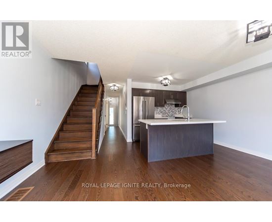 A spacious room with a staircase leading to the upper level.