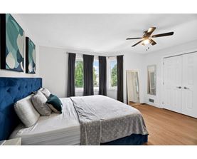 A bedroom with a large bed and a ceiling fan.