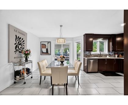 A modern dining room with a glass table and chairs.
