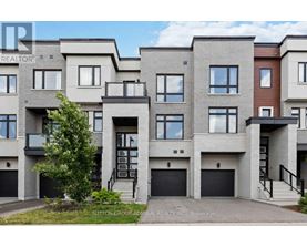 A row of modern townhouses with garages and balconies.