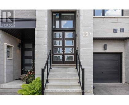 The image shows the front of a building with the number 107 and a glass door.