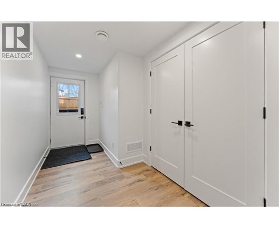 A white door with a black mat in front of it.