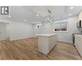 A well-lit kitchen with wooden floors and white cabinetry.