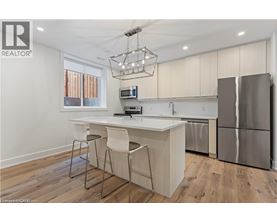 A modern kitchen with a white island and stainless steel appliances.