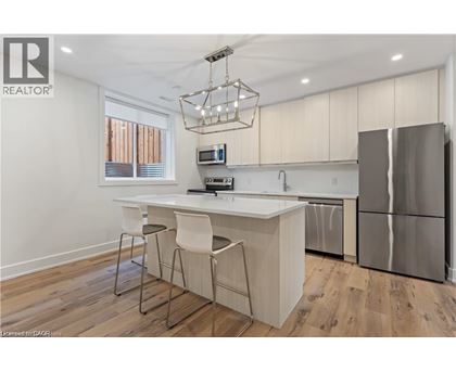 A modern kitchen with a white island and stainless steel appliances.