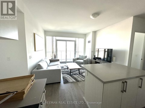 A well-lit, modern living room with a grey sofa and a wooden coffee table.