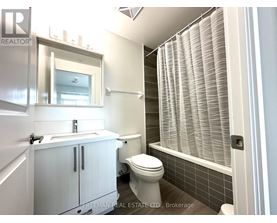 A white bathroom with a toilet, sink, and a window with blinds.