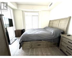 A bedroom with a bed, nightstand, and a television.