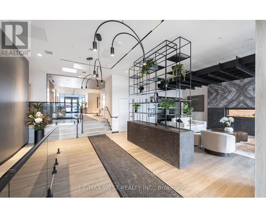 A modern interior space with a reception desk and hanging plants.