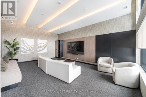 A modern living room with a large television and comfortable seating.