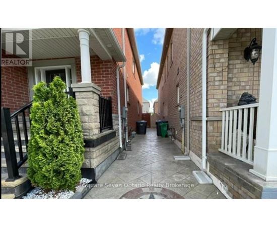 A narrow alley with a tree and a trash can.