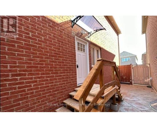A small patio with a white door and a wooden bench.