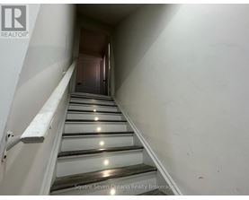 A staircase with a metal railing and wooden steps.