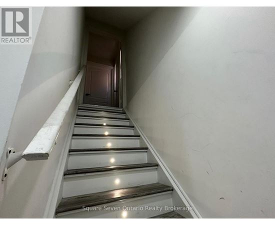 A staircase with a metal railing and wooden steps.