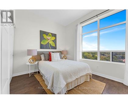 A bedroom with a large bed and a painting on the wall.
