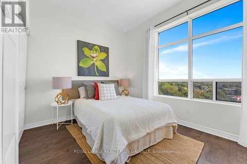 A bedroom with a large bed and a painting on the wall.