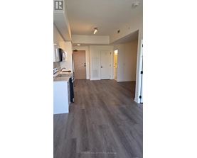 A spacious room with wooden flooring and white walls.