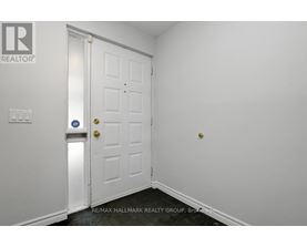 A white door with a gold handle and a blue sign on the wall.