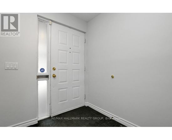 A white door with a gold handle and a blue sign on the wall.