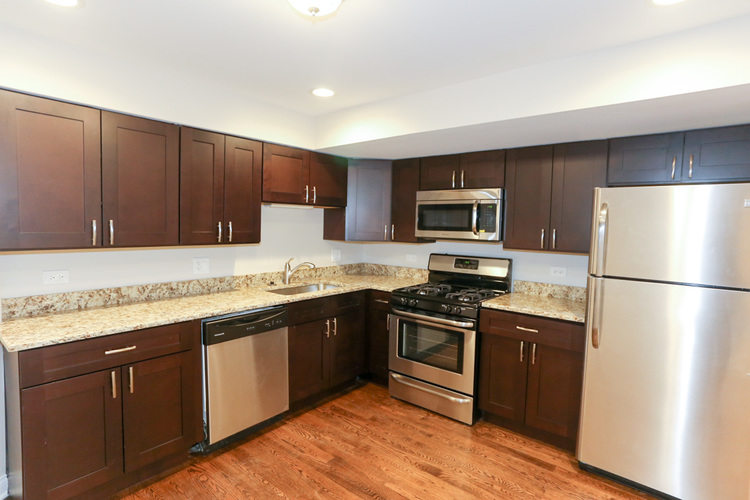 A kitchen with brown cabinets and stainless steel appliances.