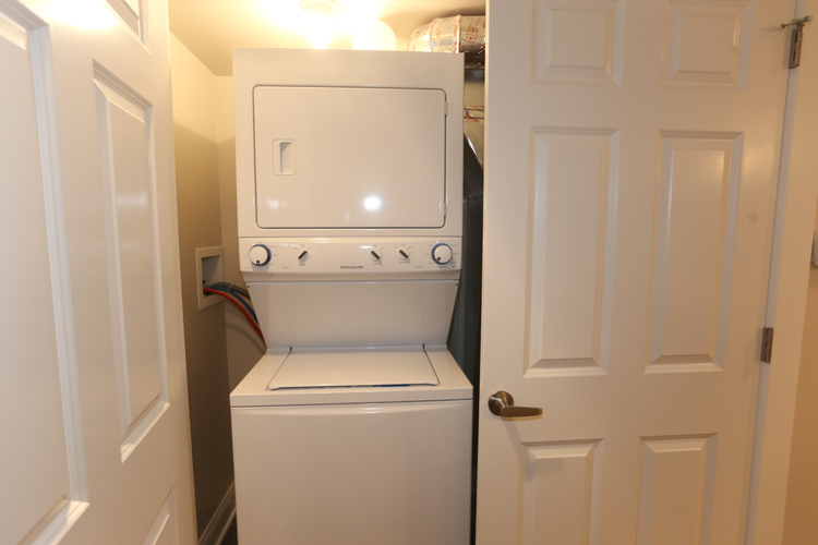 A white dishwasher is in a narrow space between two doors.