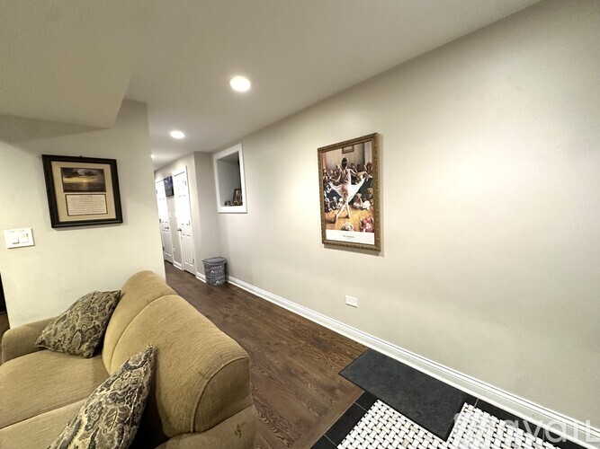A living room with a couch and a painting on the wall.