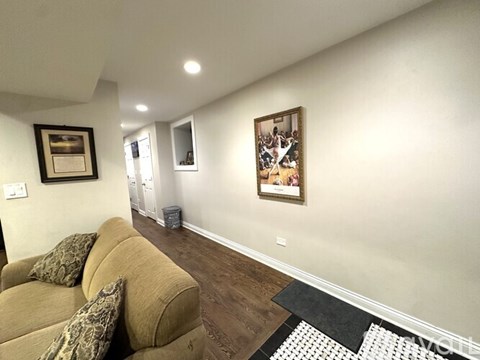 A living room with a couch and a painting on the wall.