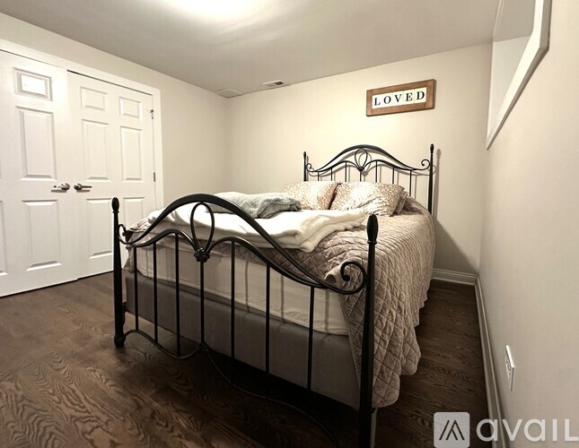 A bedroom with a bed and a sign that says "LOVED".