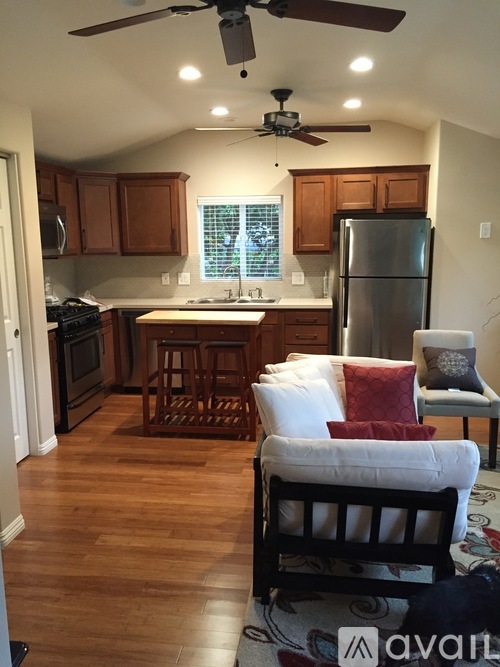 A kitchen with wooden floors and a ceiling fan.