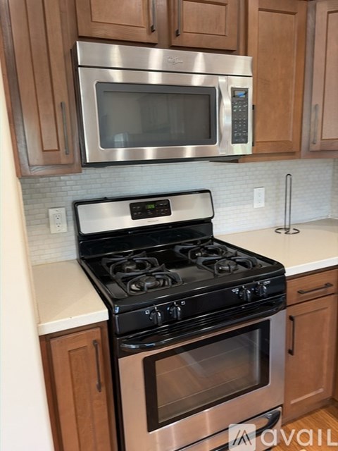 A modern kitchen with a stainless steel stove and microwave above it.