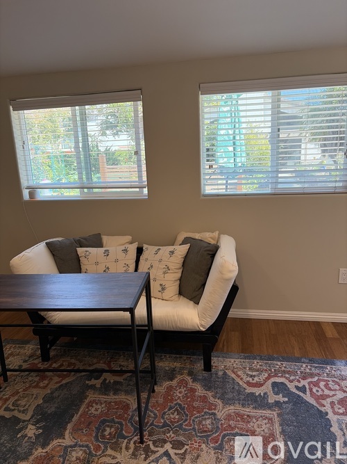 A living room with a sofa, a table, and a rug.