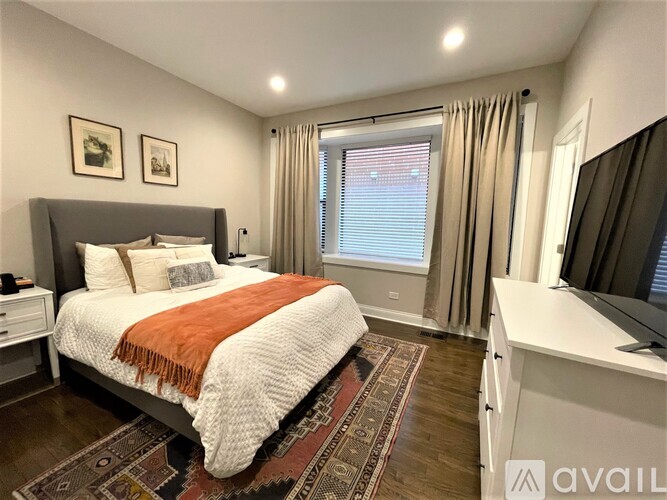 A bedroom with a large bed and a television.