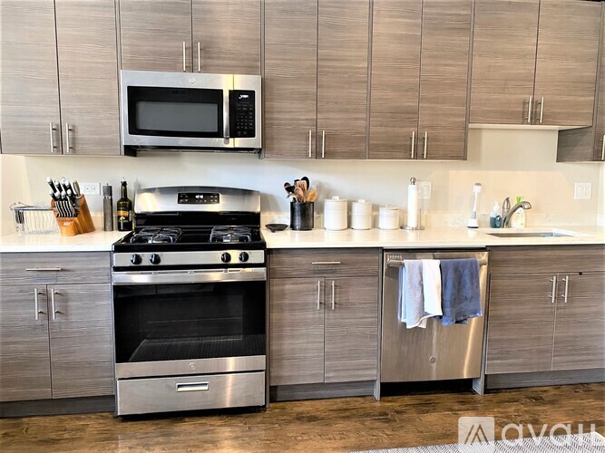 A modern kitchen with a stainless steel oven and microwave above it.