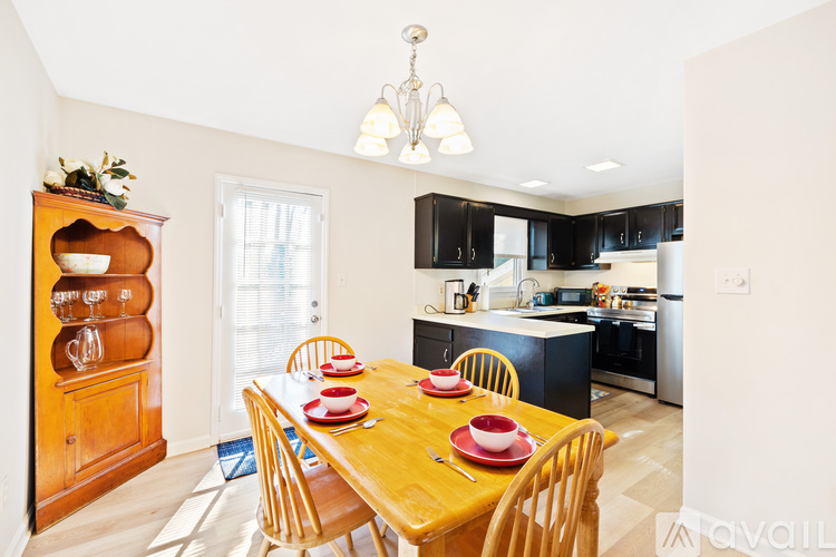 A dining room with a wooden table set for four.