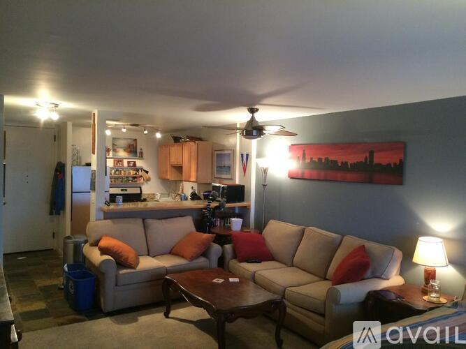 A living room with a couch, a coffee table, and a ceiling fan.