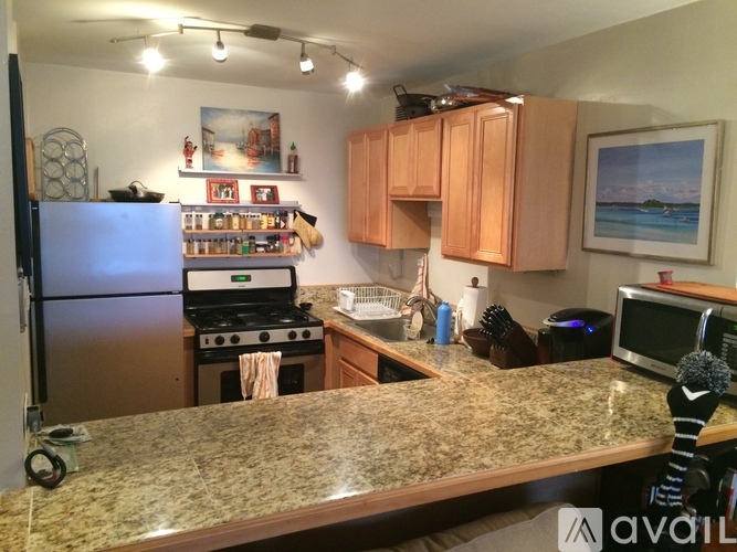 A kitchen with granite countertops and wooden cabinets.