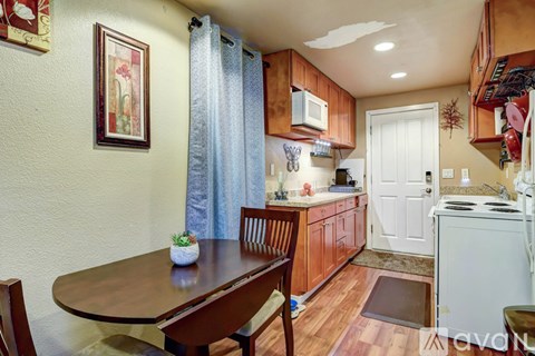A kitchen with wooden cabinets and a table with chairs.