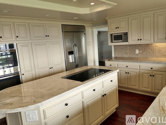 A kitchen with wooden cabinets and a marble countertop.