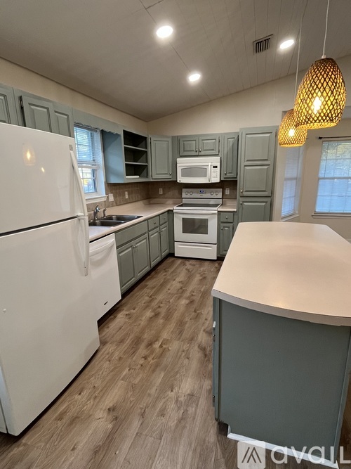 A kitchen with a white refrigerator and wooden floors.