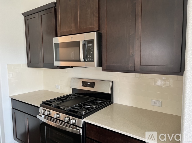 A kitchen with a stove and microwave built into the cabinetry.
