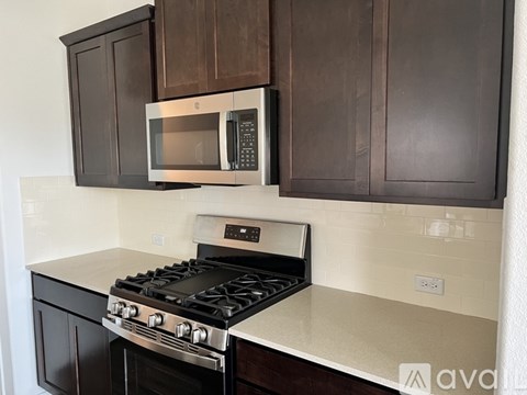 A kitchen with a stove and microwave built into the cabinetry.