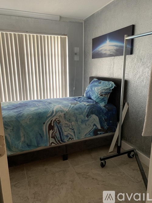 A bedroom with a bed and a painting on the wall.