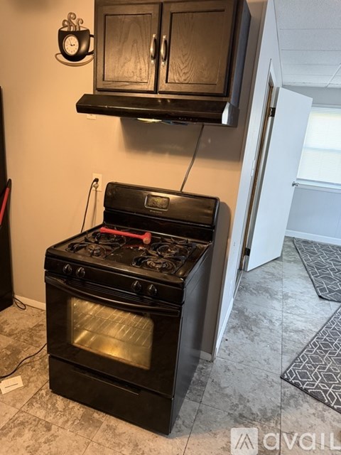 A black stove with a pot on it in a kitchen.